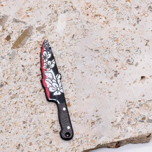 Detailed view of bloody acrylic chef knife pendant with floral patterns for DIY jewelry