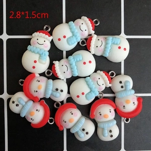 Détail macro de pendentifs bonhommes de neige en résine avec bonnets rouges et boucles
