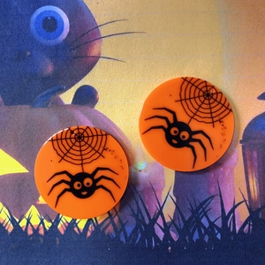 Detail der orangefarbenen Halloween-Anhänger aus Acryl mit schwarzen Spinnenmustern