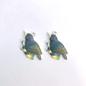 Detail view of colorful resin bird pendants with blue wings and yellow beak for DIY jewelry