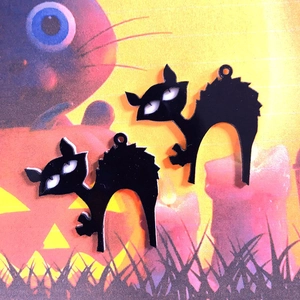 Detail von zwei schwarzen Acryl-Katzenanhängern mit gewölbtem Rücken für Halloween DIY-Schmuck