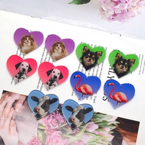 Platliggende weergave van hartvormige acryl dierenhangers met kat-, hond- en koemotieven