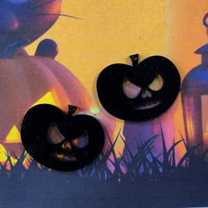 Makroaufnahme von zwei schwarzen Kürbisanhängern aus Acryl für Halloween DIY-Schmuck