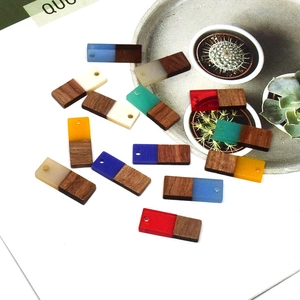 Detailed macro view of rectangular resin and wood geometric charms for DIY jewelry making