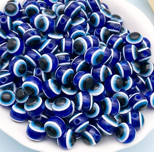 Macro shot of bulk blue resin evil eye beads for handmade jewelry making and DIY crafts