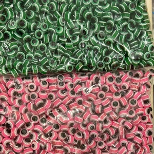 Bulk packs of green and pink resin evil eye beads for handmade jewelry DIY projects