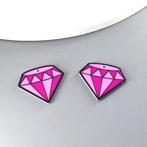 Close-up of pink diamond-shaped acrylic pendants with pre-drilled holes for DIY jewelry