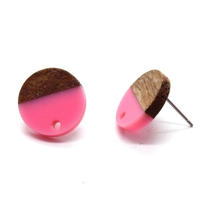 Detail of round wood and pink resin stud earrings with a smooth polished texture