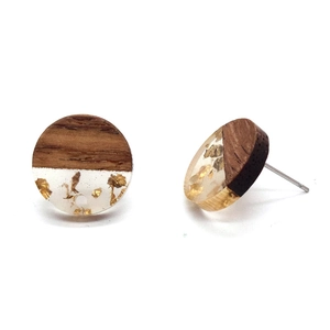 Macro detail of round wooden earrings featuring gold foil resin inlay and steel pins