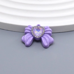 Detalle de colgante de lazo morado con ópalo de corazón y diamantes de imitación brillantes