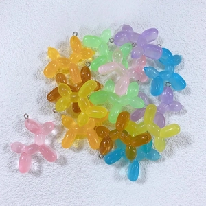 Detailed macro view of colorful translucent resin balloon dog charms with metal rings