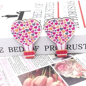 Detail of heart hot air balloon wooden pendants with colorful print on a white book