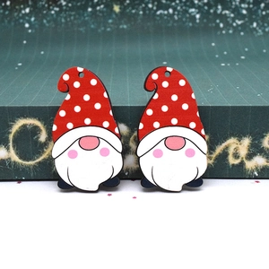 Two Christmas gnome wooden pendants with red polka dot hats on festive starry background