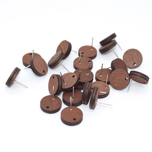 Detail of round dark brown wood earring studs with silver pins for DIY jewelry making