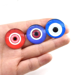 Dettaglio di ciondoli occhio malvagio in vetro rosso, viola e blu per gioielli DIY