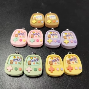 Close-up of colorful resin game console charms with mini metal rings and bear patterns