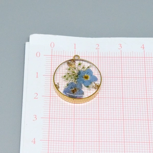 Pendentif rond en résine avec fleurs violettes et flocons d'or sur cadre doré