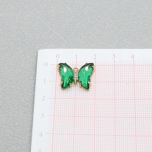 Détail du pendentif papillon en cristal vert avec dorure et strass blancs