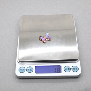 Balance numérique affichant un poids de 1,8 g pour le pendentif papillon en cristal