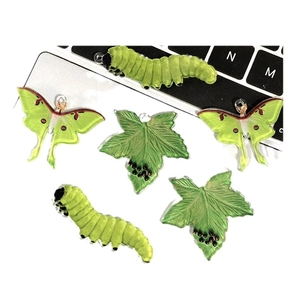 DIY-hangers van acryl met groene rups, maanvlinder en bladvormen op een toetsenbord