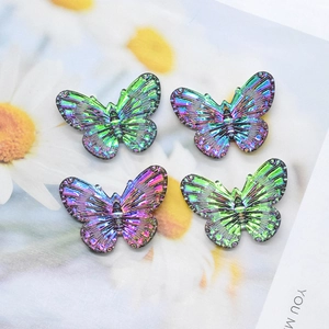 Close-up of four iridescent butterfly charms with detailed texture for DIY jewelry