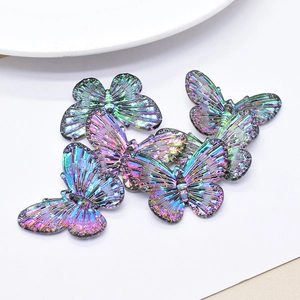 Macro shot of 6 iridescent butterfly charms with rainbow laser finish on white background