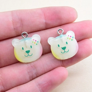 Detail of cute bear resin charms with star ears and colorful gradient effect on hand