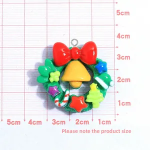 Detailed macro view of a 3.5cm resin Christmas wreath charm with a ruler for size reference