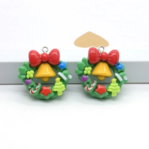 Macro detail of Christmas wreath charms with red bows and tiny bells for DIY jewelry