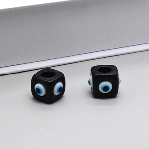 Gros plan de deux perles carrées en résine noire œil protecteur pour création de bijoux