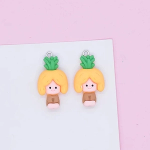 Close-up of two pineapple girl resin charms for DIY jewelry making on a pink background
