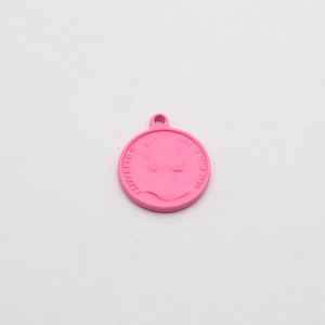 Macro detail of round pink alloy pendant featuring Queen Elizabeth II relief for DIY jewelry