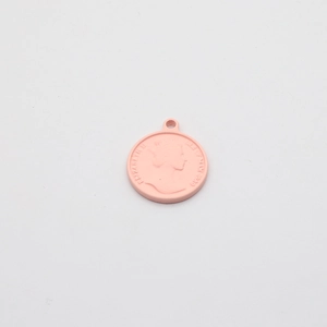 Macro shot of pink matte Elizabeth II coin pendant with embossed relief for jewelry DIY