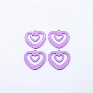 Close-up of four purple alloy heart-shaped hollow charms for DIY earring and necklace making