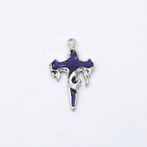 Détail d'un pendentif croix punk argenté avec incrustation d'émail bleu fluide