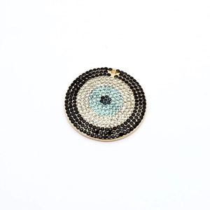 Makroansicht von Evil Eye Anhänger mit Goldbeschichtung und blauen Kristallsteinen