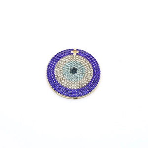 Detailansicht eines runden Strass-Amuletts mit bösem Blick und Goldbeschichtung
