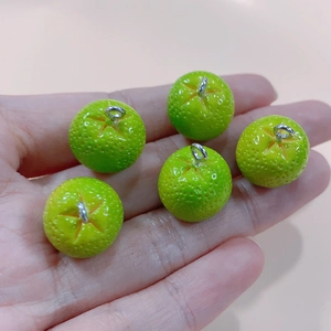 Detailed view of 3D green citrus resin charms with textured fruit peel and metal rings