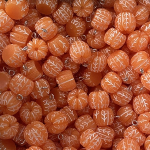 Macro view of 3D orange resin fruit pendants with silver loops for DIY jewelry making