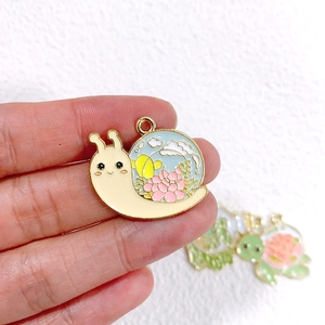 Nahaufnahme eines bunten Emaille-Schneckenanhängers mit Blumenmuster für DIY-Schmuck