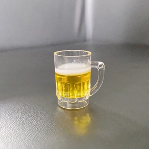 Makroaufnahme von Miniatur-Bierkrug-Resin-Anhänger mit realistischem Schaum und gelbem Harz