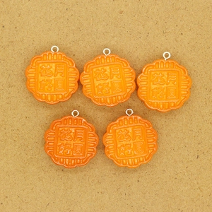 Detailed macro of a resin mooncake pendant with 3D embossed floral Chinese characters