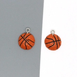 Detalle de dos colgantes de baloncesto de resina en miniatura con anillas de metal plata