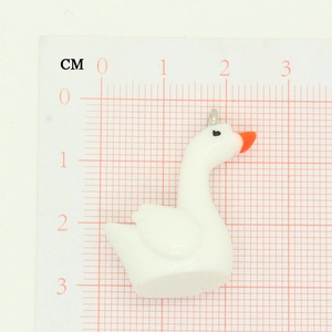 Detailed macro shot of 2.5cm white cartoon swan charm with scale for DIY jewelry