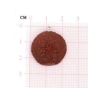 Mushroom shape resin pendant with star pattern and metal ring on measuring grid scale