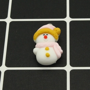 Dettaglio di un ciondolo a pupazzo di neve in resina bianca con cappello e sciarpa rosa