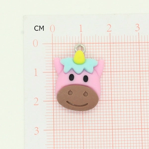 Détail d'un pendentif licorne rose en résine avec échelle de mesure et anneau métallique