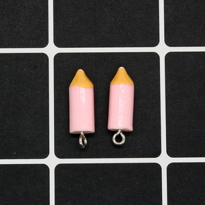 Close-up of pink pencil-shaped resin charms with silver metal rings for DIY jewelry
