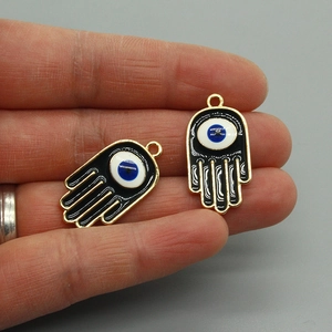 Detail van een zwart Hamsa hand-hangertje met boze oog en gouden rand voor DIY-sieraden