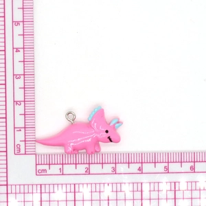 Macro-opname van roze hars dinosaurus hanger met zilveren ring voor DIY-sieraden maken
